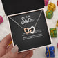 To My Sister interlocking hearts necklace with 'Side by Side or Miles Apart' message card, held in hand