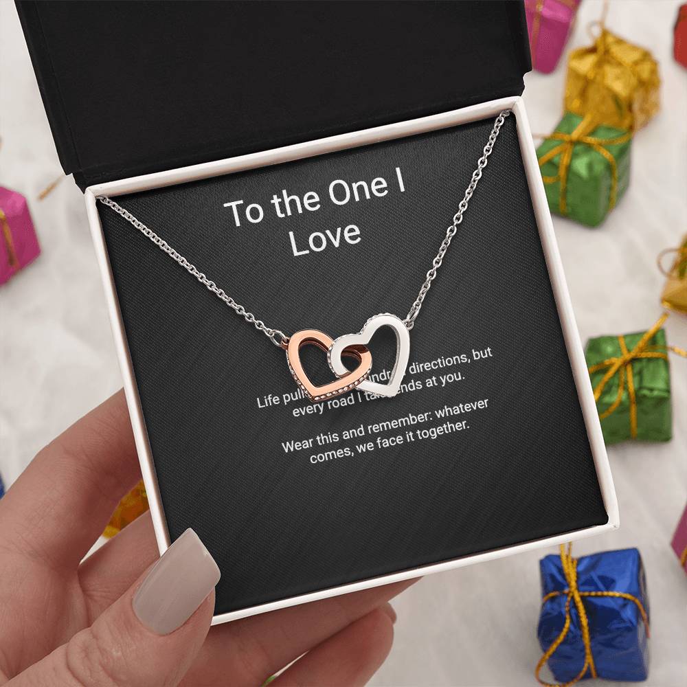 Every Road Ends at You interlocking hearts couples necklace with message card, held in hand among gifts